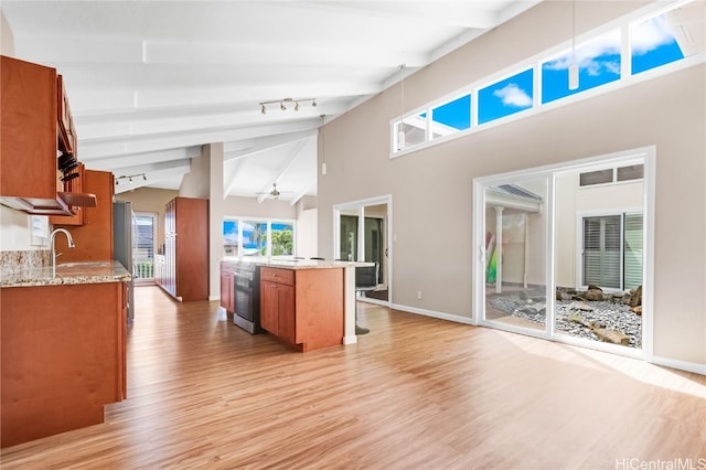 kitchen featuring light hardwood / wood-style flooring, beamed ceiling, and ceiling fan