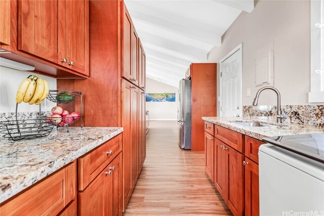 kitchen with stainless steel fridge, light stone countertops, vaulted ceiling with beams, light hardwood / wood-style flooring, and sink