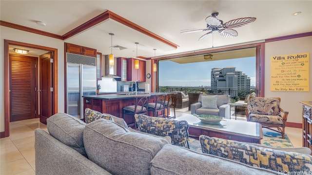 living room featuring light tile patterned floors, ceiling fan, ornamental molding, and sink