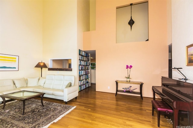 living room featuring wood finished floors and a towering ceiling