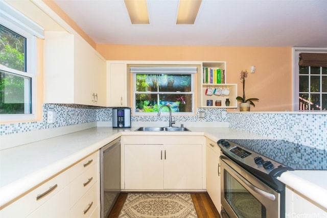 kitchen with white cabinets, dark hardwood / wood-style flooring, backsplash, stainless steel appliances, and sink