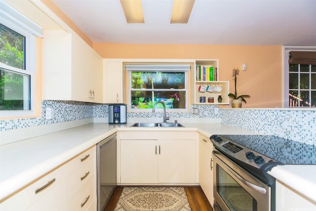kitchen featuring appliances with stainless steel finishes, backsplash, light countertops, and a sink