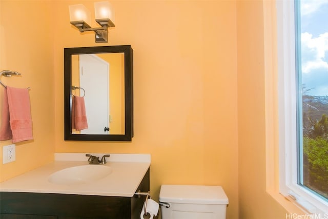 bathroom featuring vanity, toilet, and a healthy amount of sunlight