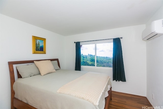 bedroom featuring dark wood-type flooring and an AC wall unit