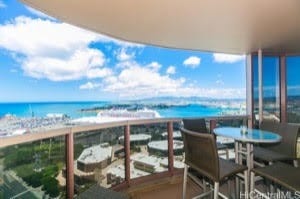 balcony featuring a water view and a view of the beach