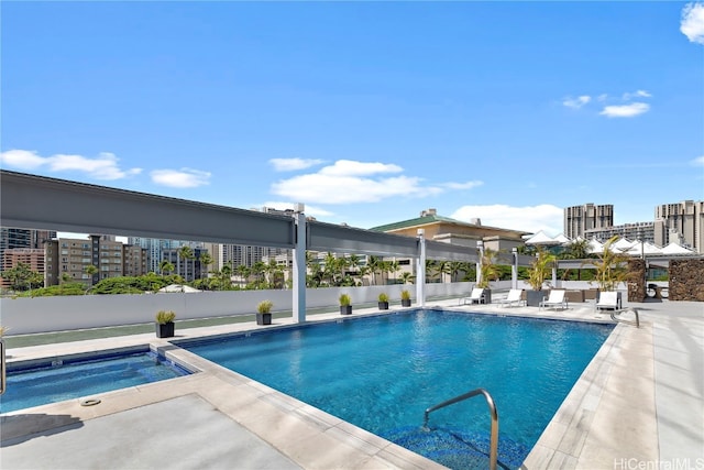 view of swimming pool featuring a patio and an in ground hot tub