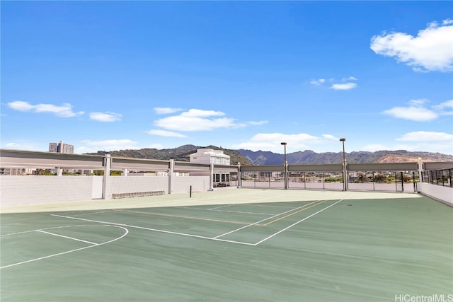 view of sport court featuring a mountain view and basketball hoop