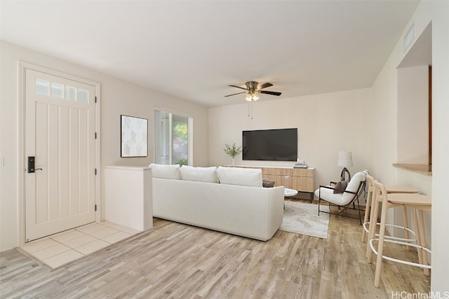 living room featuring ceiling fan and light hardwood / wood-style flooring