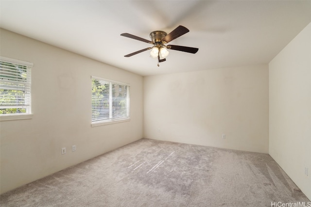 carpeted spare room with ceiling fan