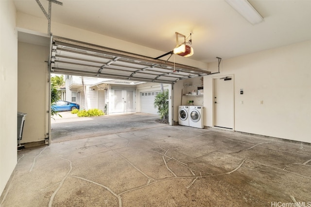 garage with a garage door opener and independent washer and dryer