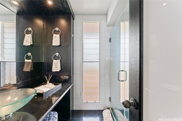 bathroom with tile walls, tile patterned floors, and an enclosed shower