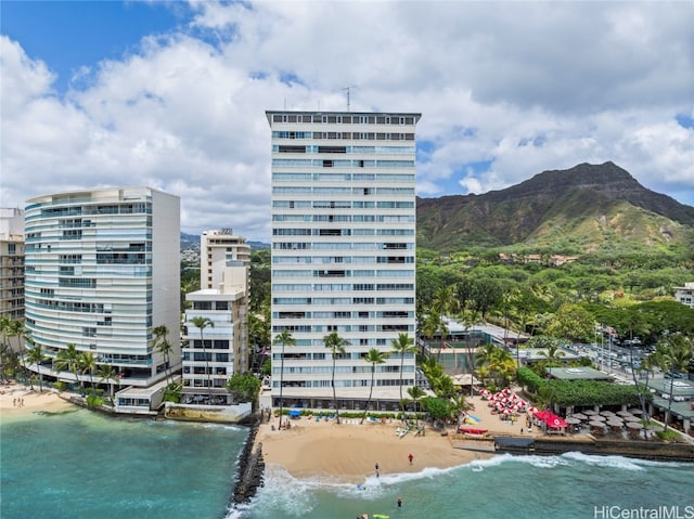 view of property featuring a water and mountain view and a beach view