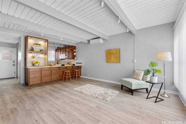 living area with light hardwood / wood-style floors, beamed ceiling, and a wall unit AC