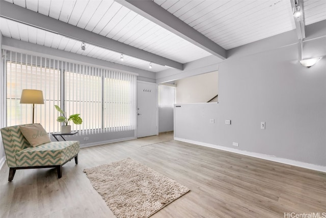 sitting room with beam ceiling and wood-type flooring