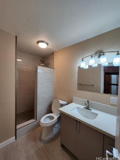 bathroom featuring vanity, toilet, and tiled shower