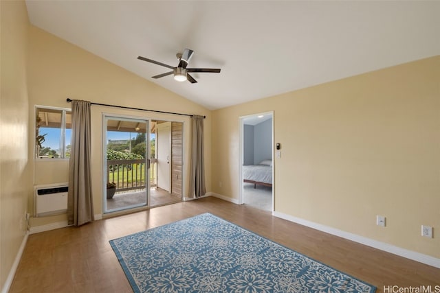 interior space featuring vaulted ceiling, an AC wall unit, hardwood / wood-style floors, and ceiling fan