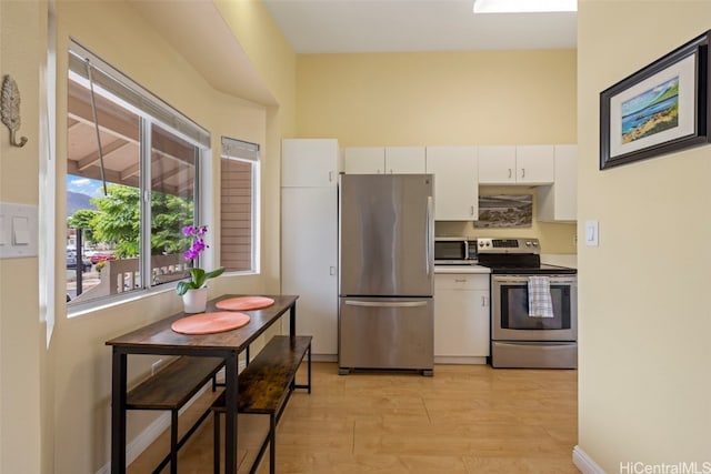 kitchen with white cabinetry, light wood-type flooring, and appliances with stainless steel finishes