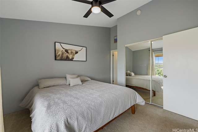 carpeted bedroom featuring lofted ceiling, ceiling fan, and a closet