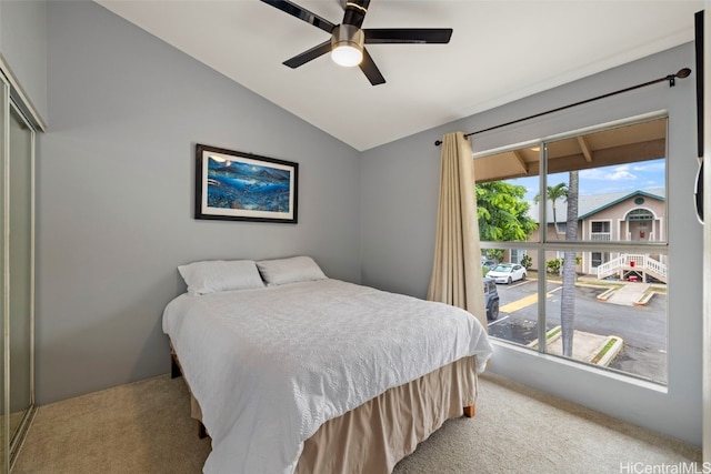 carpeted bedroom with multiple windows, lofted ceiling, a closet, and ceiling fan