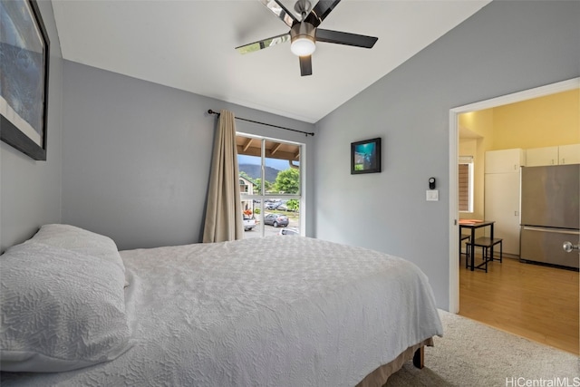 bedroom featuring hardwood / wood-style flooring, ceiling fan, stainless steel fridge, and vaulted ceiling