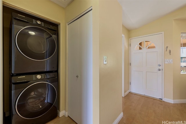 washroom with light wood-type flooring and stacked washer / dryer