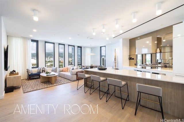 kitchen featuring a breakfast bar area, plenty of natural light, and light wood-type flooring