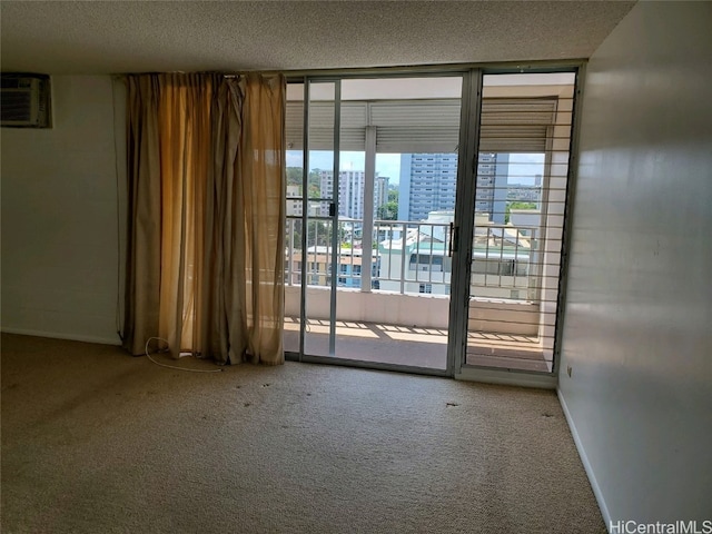 carpeted empty room with an AC wall unit and a textured ceiling