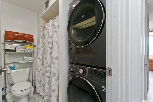 laundry room with stacked washer and dryer