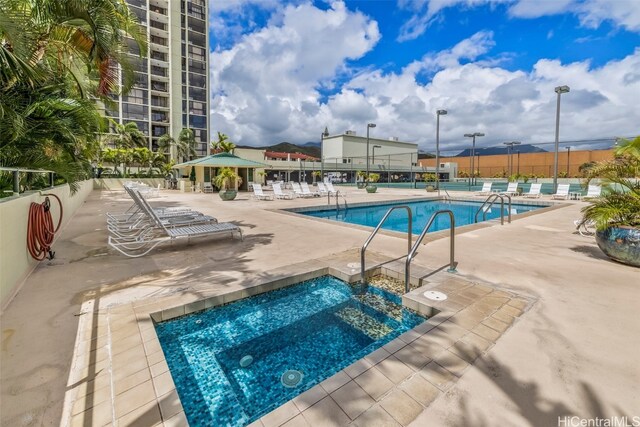 view of swimming pool featuring a patio, a gazebo, and a community hot tub