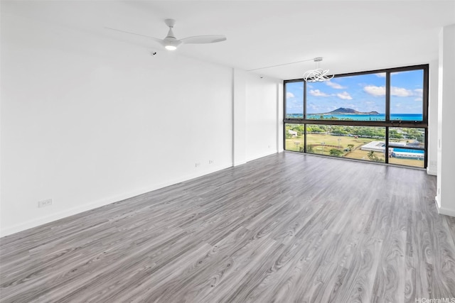 322 Aoloa St Unit Ph-9, Kailua, HI 96734 - spare room with floor to ceiling windows, wood finished floors, and ceiling fan with notable chandelier