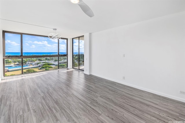 322 Aoloa St Unit Ph-9, Kailua, HI 96734 - unfurnished room featuring expansive windows, baseboards, wood finished floors, and ceiling fan with notable chandelier