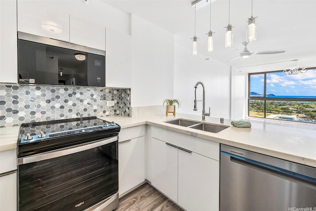 322 Aoloa St Unit Ph-9, Kailua, HI 96734 - kitchen with white cabinets, appliances with stainless steel finishes, a sink, light countertops, and tasteful backsplash
