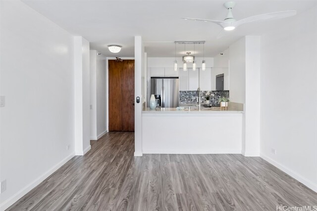 kitchen with light hardwood / wood-style floors, stainless steel fridge with ice dispenser, and white cabinets