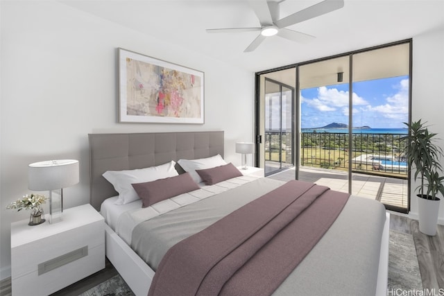 bedroom featuring dark wood-type flooring, multiple windows, access to exterior, and ceiling fan