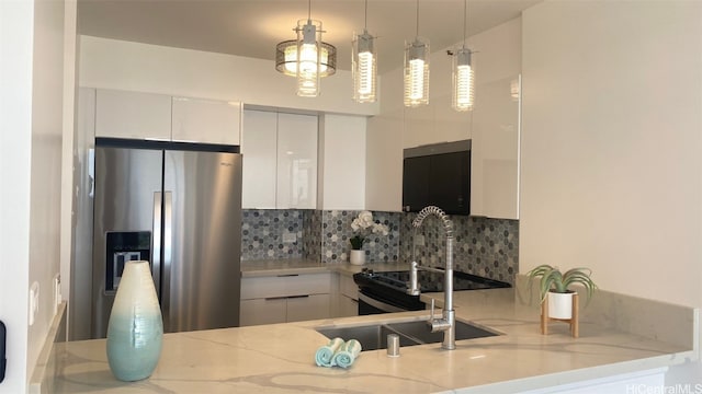 kitchen featuring light stone countertops, white cabinets, stainless steel refrigerator with ice dispenser, and decorative light fixtures