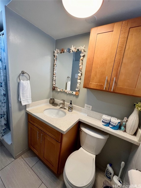 bathroom featuring vanity, a shower with shower curtain, toilet, and tile patterned floors