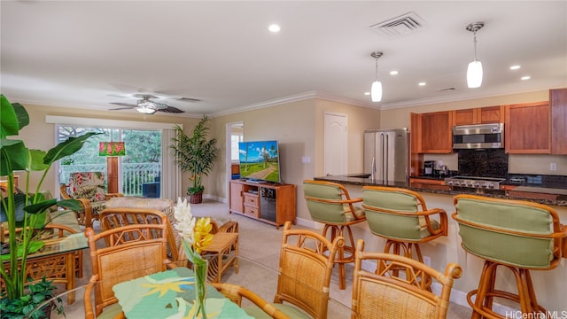 kitchen with stainless steel appliances, tasteful backsplash, decorative light fixtures, light colored carpet, and ceiling fan