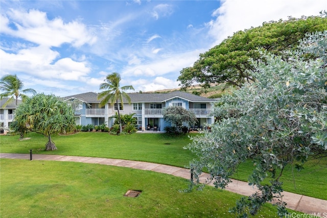 view of front of property with a front yard and a balcony