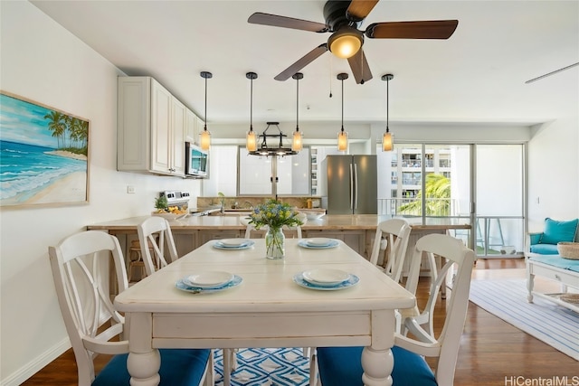 dining area featuring dark wood-type flooring and ceiling fan