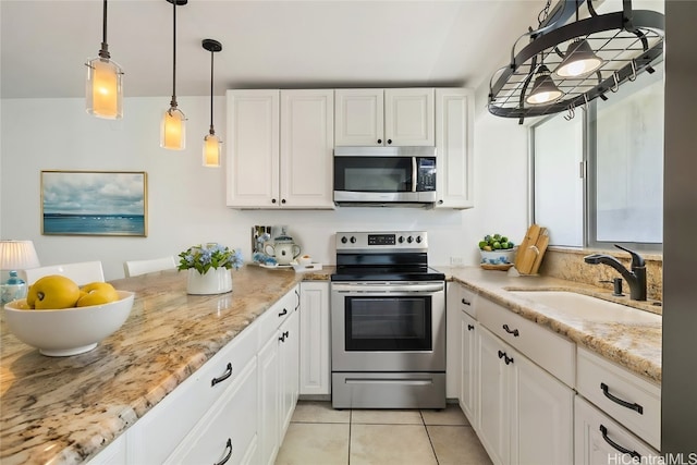 kitchen featuring sink, stainless steel appliances, white cabinets, light stone counters, and light tile patterned floors