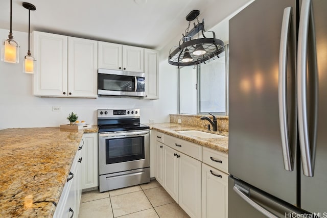 kitchen featuring hanging light fixtures, sink, light stone countertops, white cabinets, and appliances with stainless steel finishes