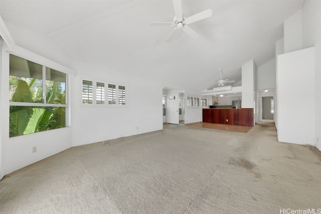 unfurnished living room featuring light carpet, high vaulted ceiling, and ceiling fan