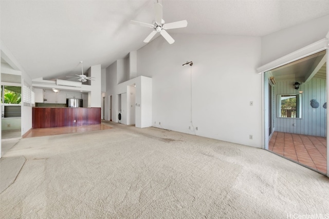 unfurnished living room featuring light carpet, high vaulted ceiling, and ceiling fan