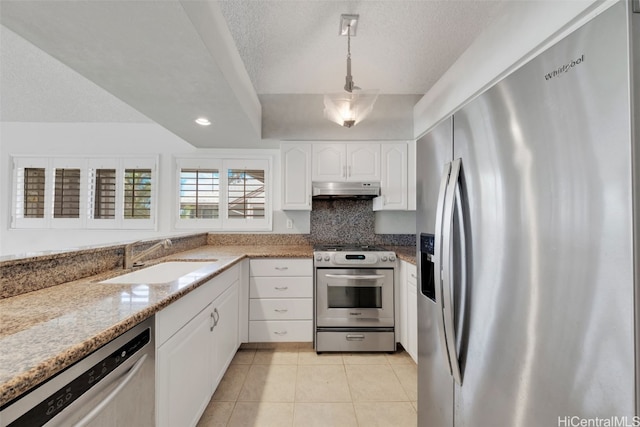 kitchen featuring white cabinetry, stainless steel appliances, sink, decorative light fixtures, and light stone counters