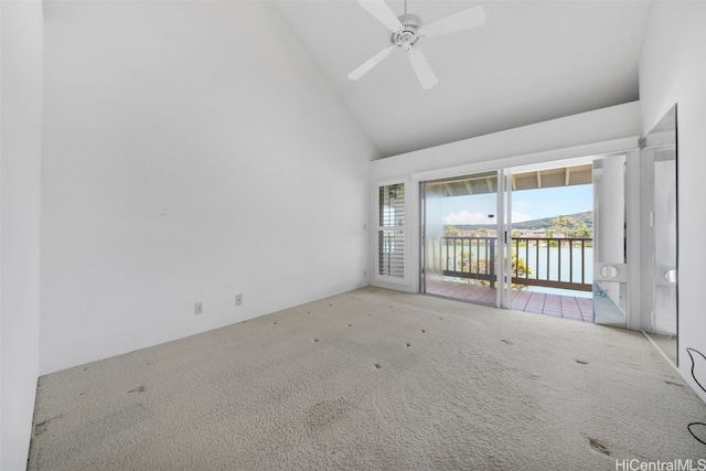 carpeted empty room featuring a water view, high vaulted ceiling, and ceiling fan