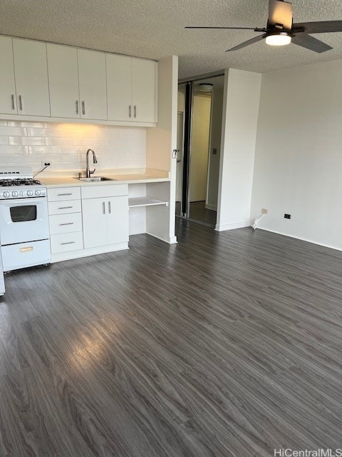 kitchen with sink, a textured ceiling, dark hardwood / wood-style flooring, white cabinetry, and white range with gas cooktop