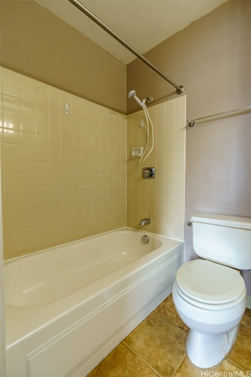 bathroom featuring toilet, tile patterned floors, and tiled shower / bath combo