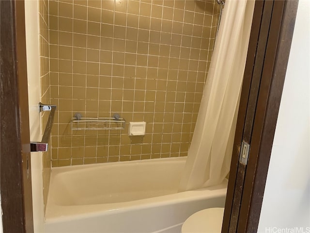 bathroom featuring shower / tub combo with curtain and toilet