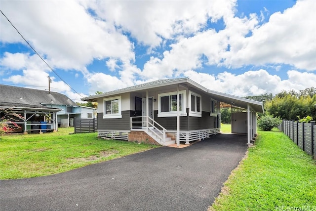 view of front of property featuring a front lawn, entry steps, aphalt driveway, fence, and a carport