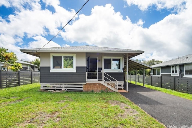 view of front of house featuring a carport, aphalt driveway, a front lawn, and fence